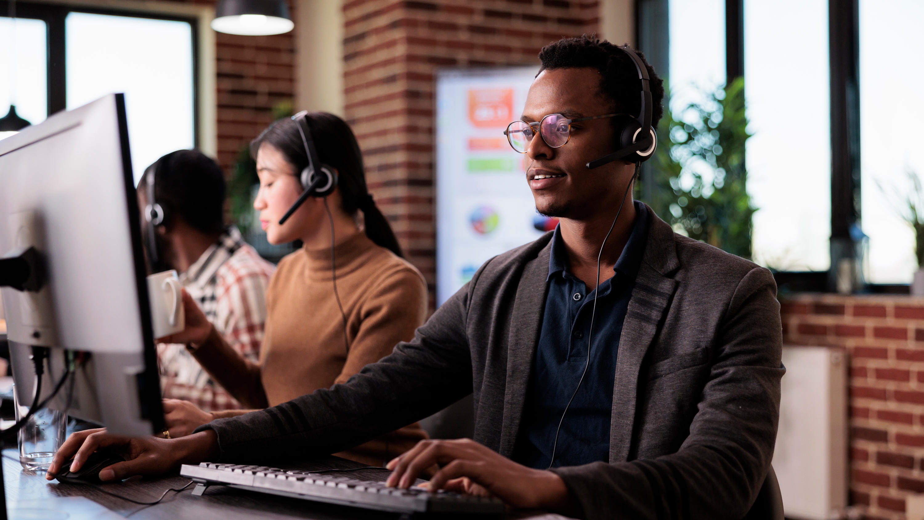 1african-american-helpline-employee-working-call-center-reception-with-multiple-monitors-male-operator-using-telecommunication-help-clients-customer-service-support-remote-network